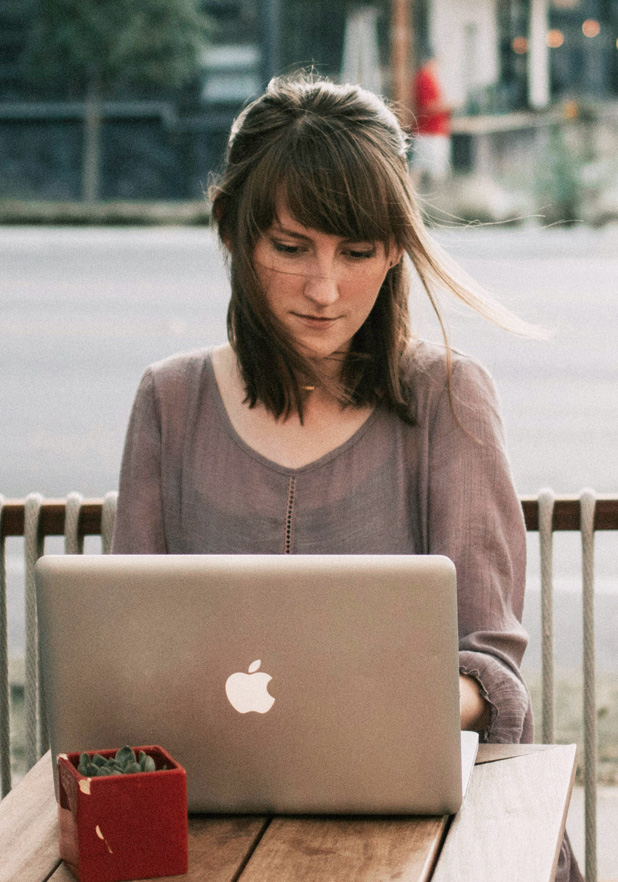 Woman outside at table with laptop