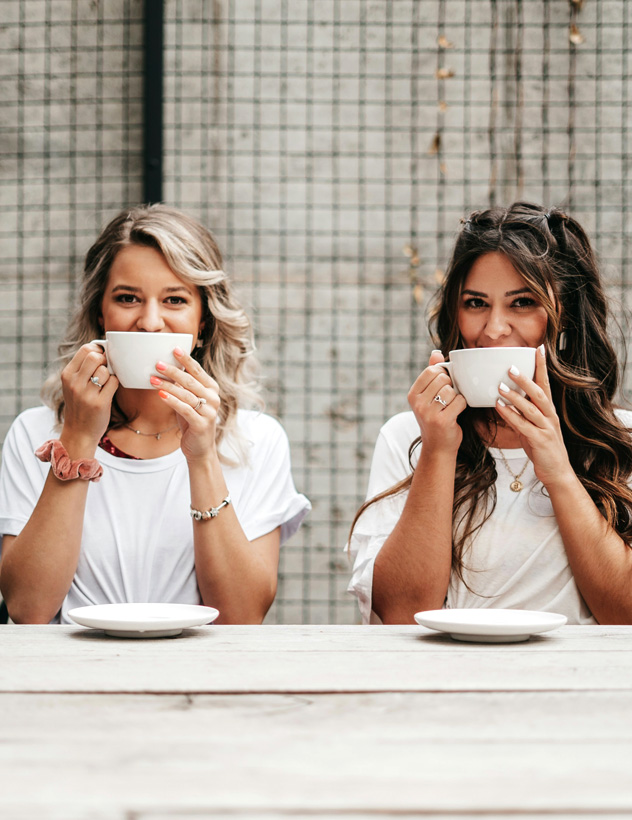 Two women with white cups